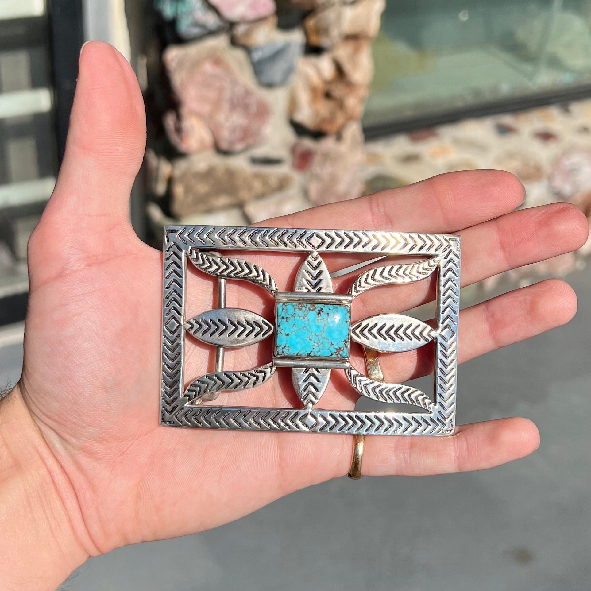 A handmade, Navajo style, sterling silver belt buckle set with a rectangular cabochon cut blue turquoise.