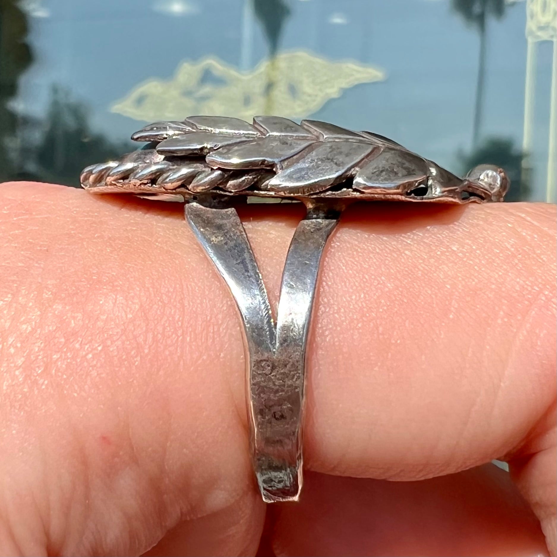 A handmade Navajo men's turquoise ring.  The ring is made with wire and carved silver.