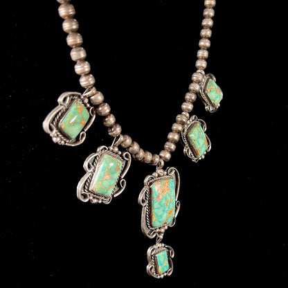 A sterling silver Navajo turquoise necklace set with Pilot Mountain Mine turquoise stones by artist Minnie Thomas.