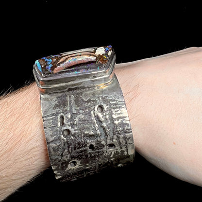A men's sterling silver cuff bracelet set with an Australian Koroit boulder opal stone, handmade by Sam Yah.