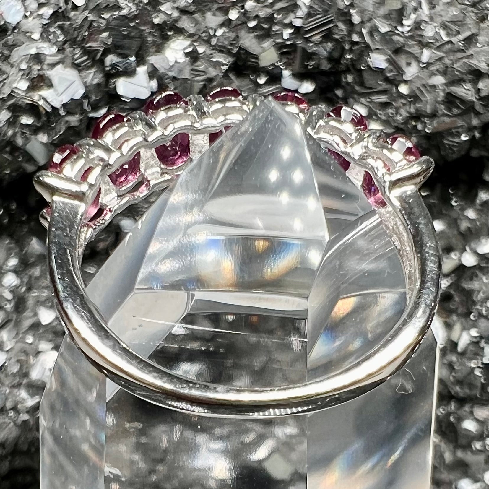 A sterling silver band set with 7 oval cut, purple rhodolite garnet stones.