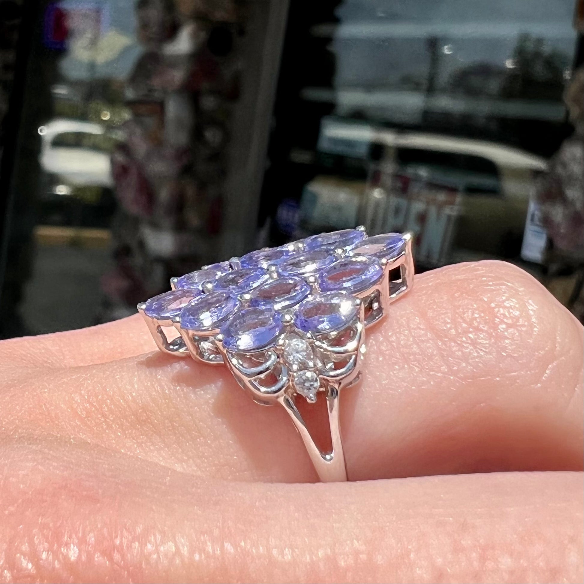 A sterling silver gemstone cluster ring set with oval cut tanzanite stones and round cubic zirconia accents.