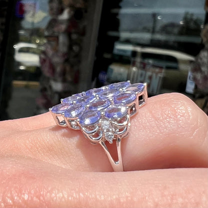 A sterling silver gemstone cluster ring set with oval cut tanzanite stones and round cubic zirconia accents.