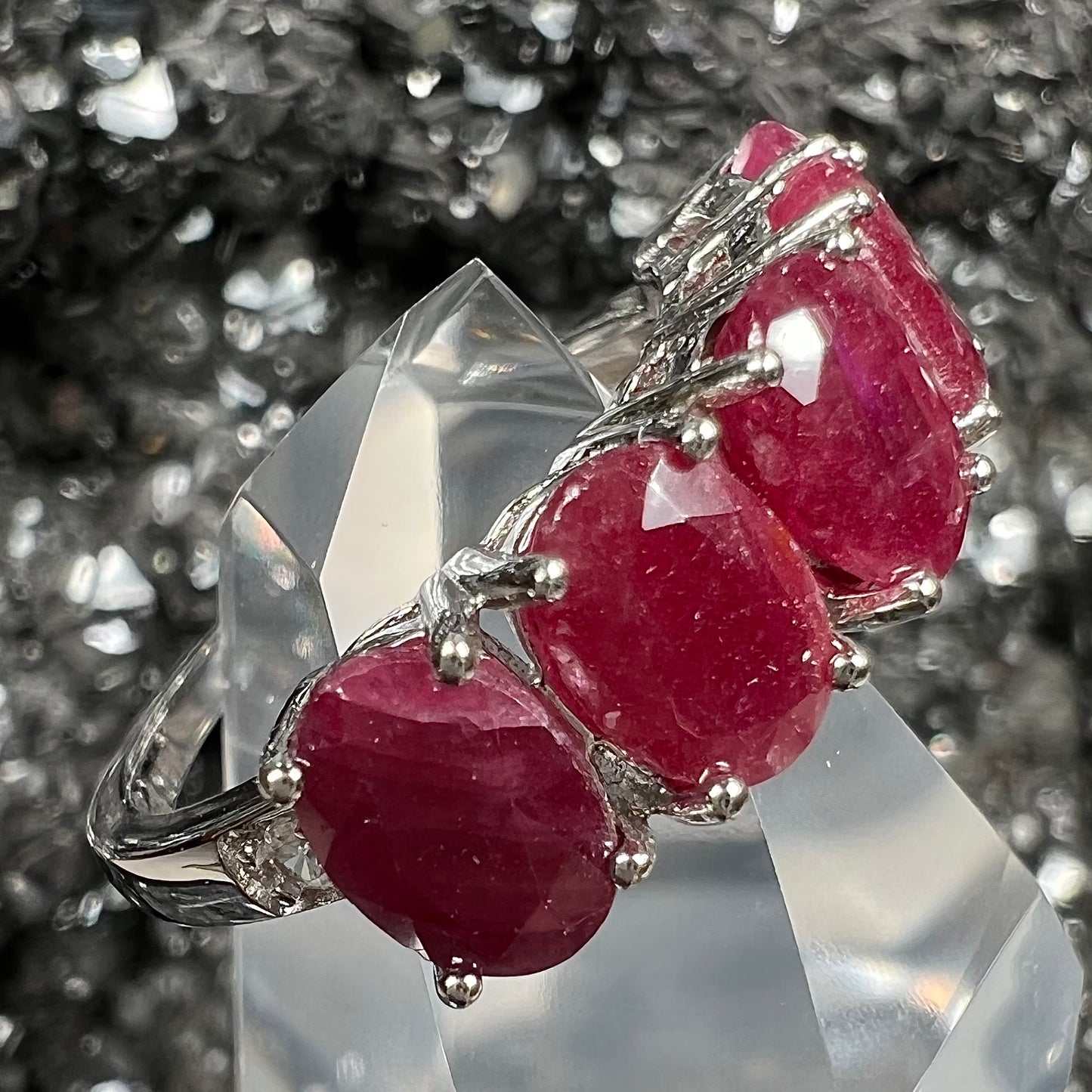 A sterling silver, five stone, faceted oval cut red ruby stackable ring.