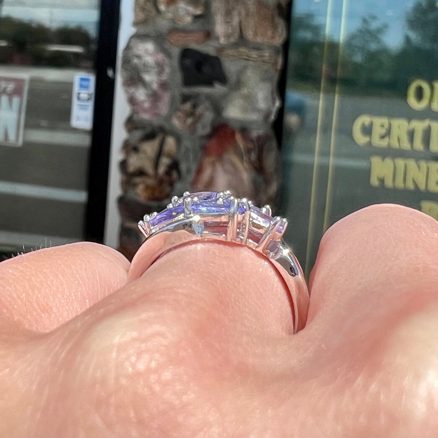 A sterling silver cluster ring prong set with seven faceted oval cut blue tanzanite stones.