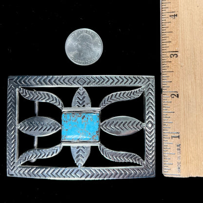 A handmade, Navajo style, sterling silver belt buckle set with a rectangular cabochon cut blue turquoise.