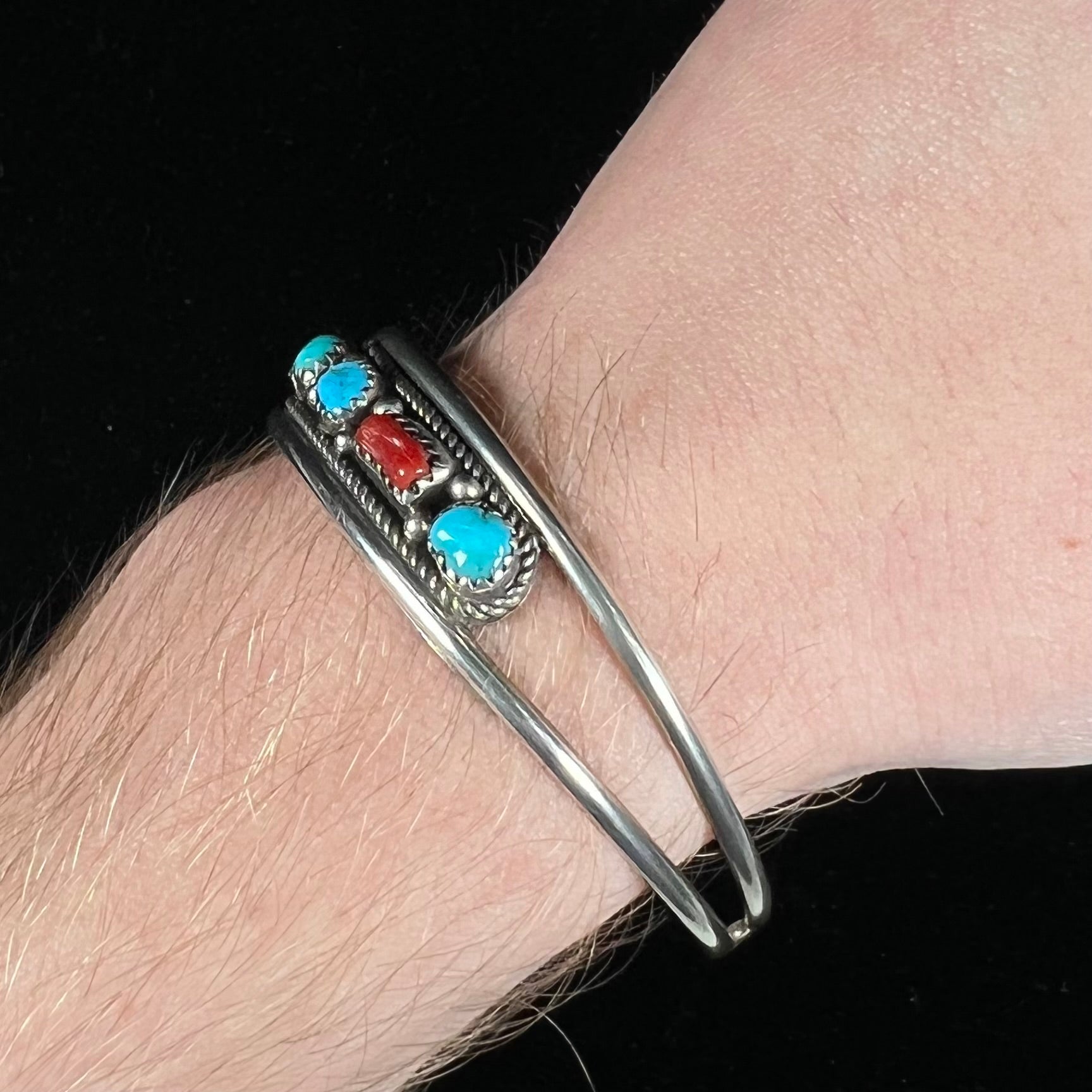 A silver ladies' turquoise and coral cuff bracelet, handmade by Navajo artist, John Delvin.