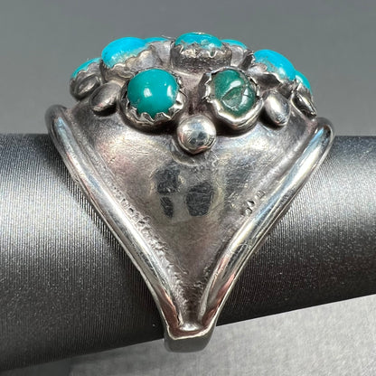 A handmade, unisex Hopi silver ring set with 14 round turquoise cabochons.