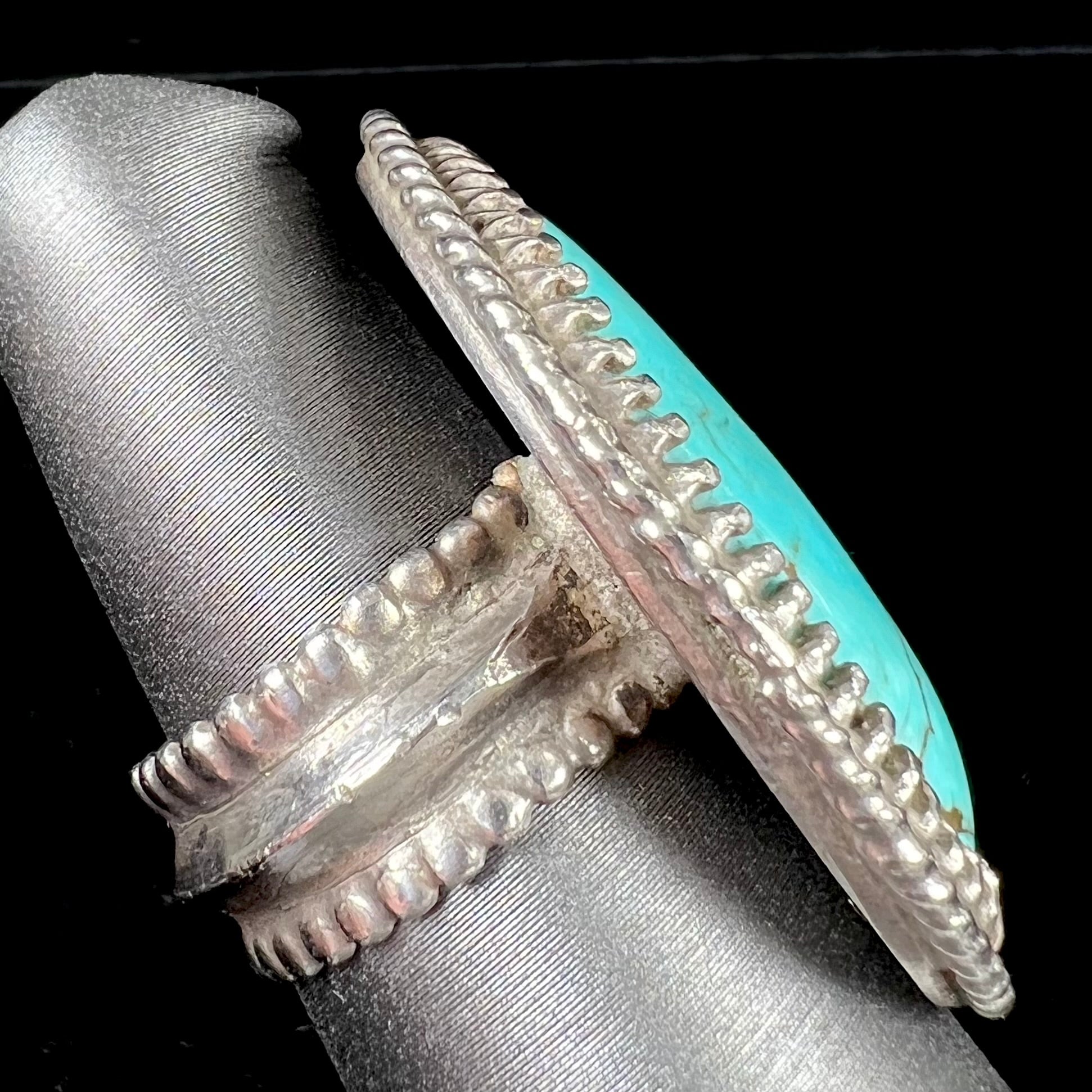 A sterling silver rope design ring set with a turquoise stone from Pilot Mountain Mine, Nevada.