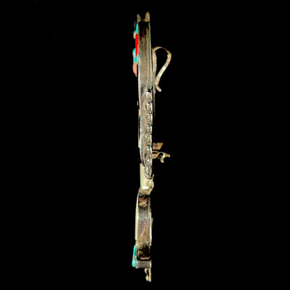 A silver, Zuni Indian dancing eagle necklace/pin.  The piece is inlaid with pieces of onyx, turquoise, coral, and mother of pearl.