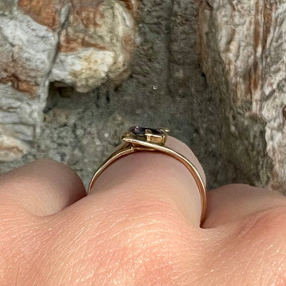 A vintage 1960's yellow gold ring set with a round synthetic purple alexandrite.  The prongs are worn.