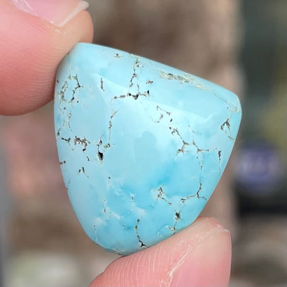 A loose, freeform cabochon cut light blue turquoise stone from Sleeping Beauty Mine, Arizona.