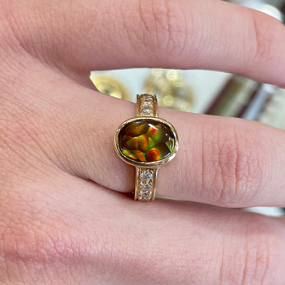 A ladies' oval cabochon cut fire agate and diamond engagement ring cast in yellow gold.