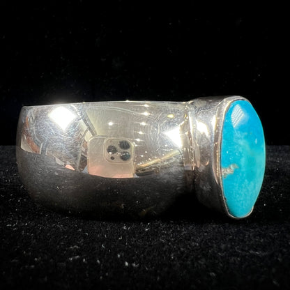A unisex sterling silver cuff bracelet set with a barrel cabochon cut turquoise from Sleeping Beauty Mine, Arizona.