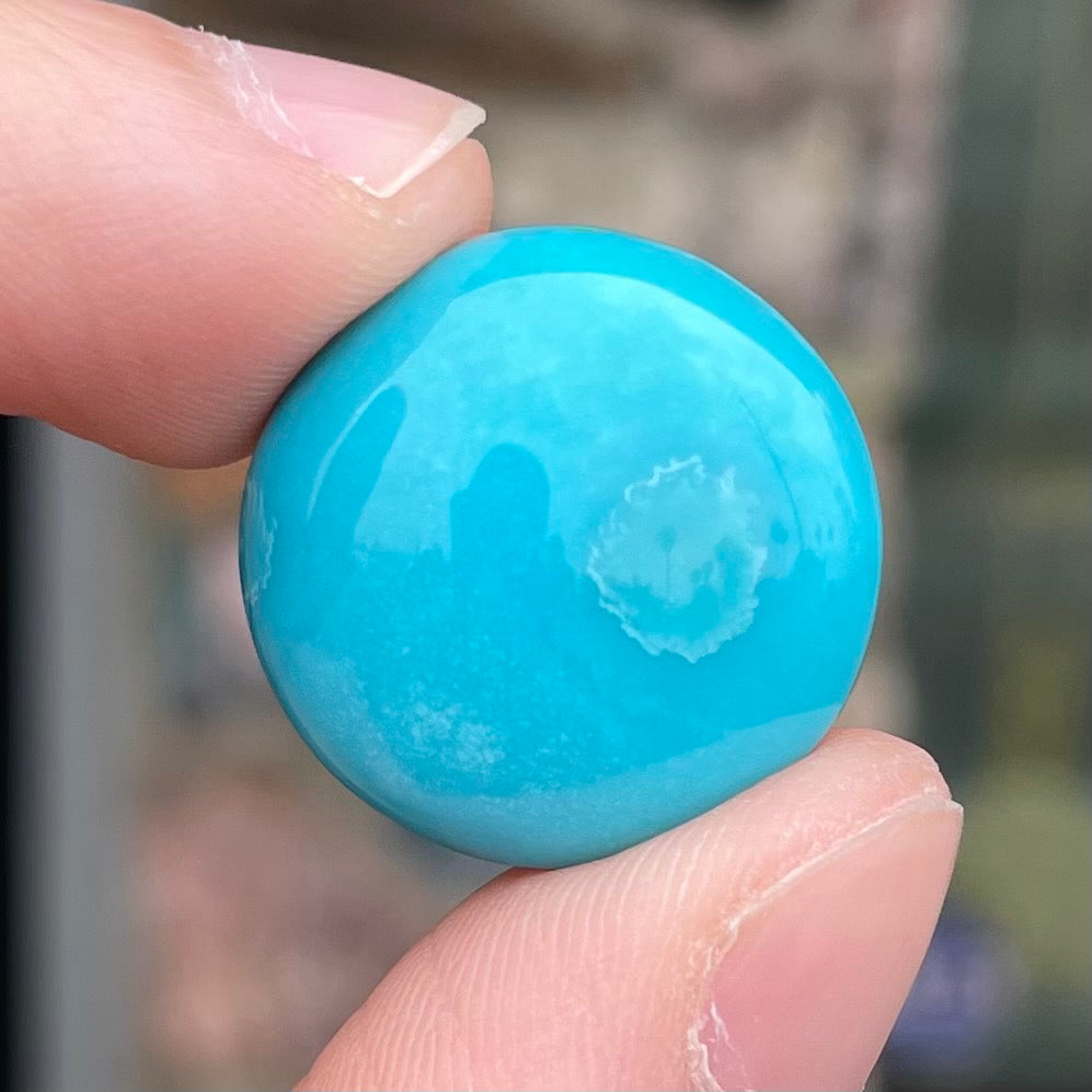 A loose, round cabochon cut turquoise stone from Sleeping Beauty Mine, Arizona.