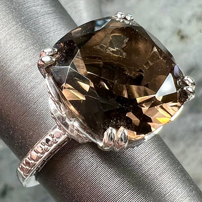 A sterling silver, cushion cut smoky quartz solitaire ring.