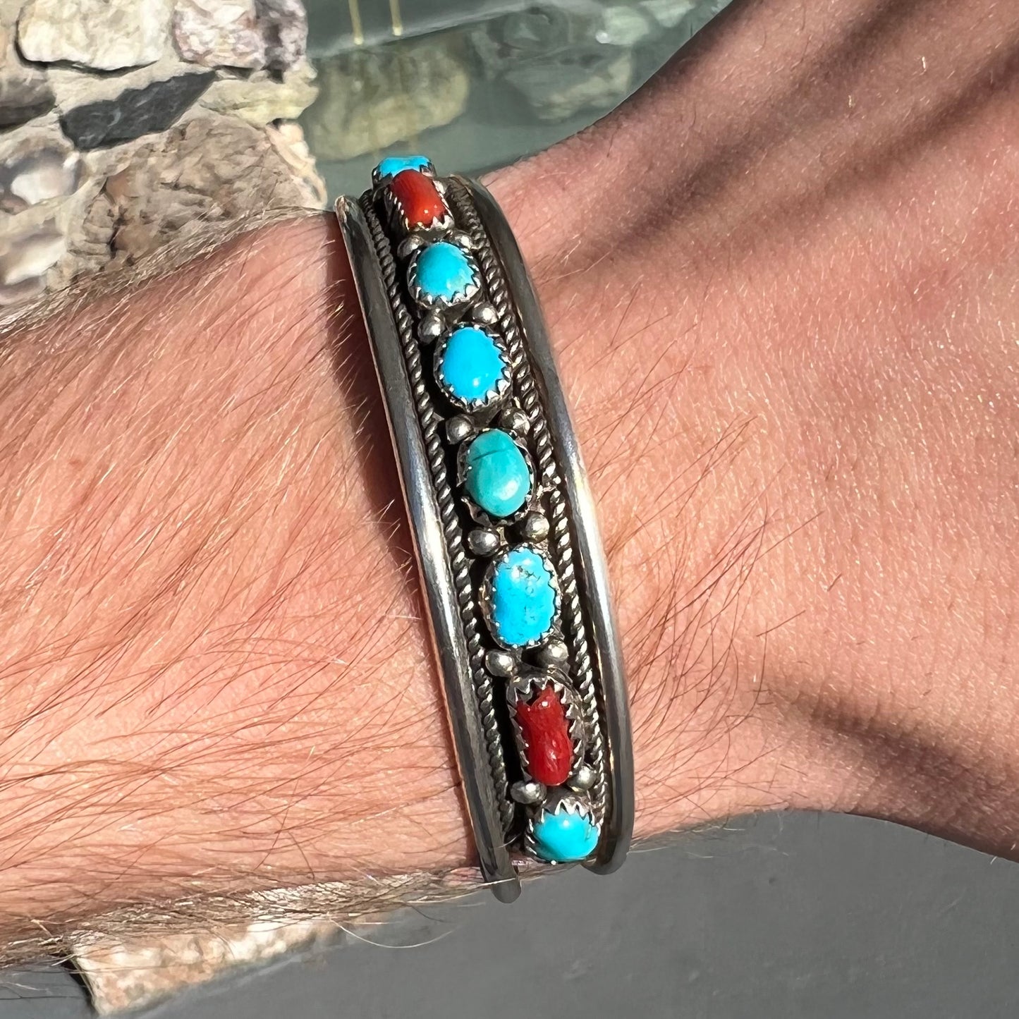 A silver ladies' turquoise and coral cuff bracelet, handmade by Navajo artist, John Delvin.