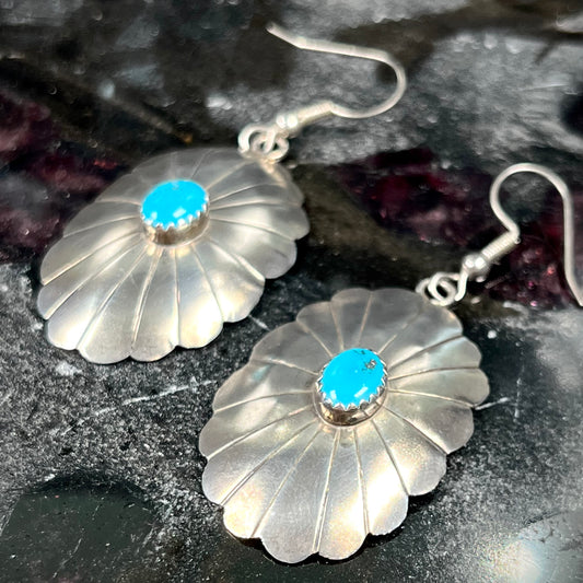 A pair of sterling silver concho turquoise dangle earrings.