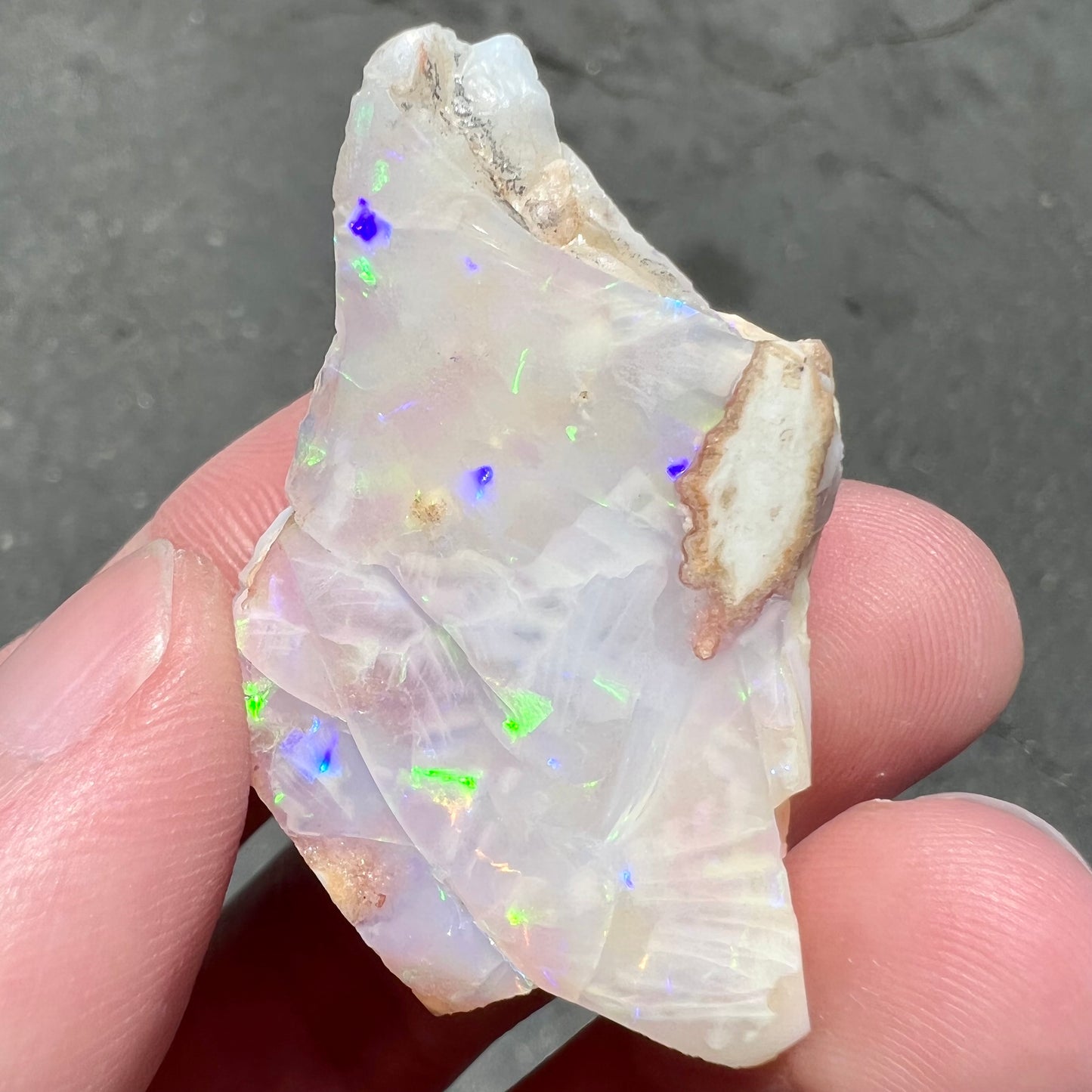 A loose, polished specimen of white crystal opal from Spencer, Idaho, USA.