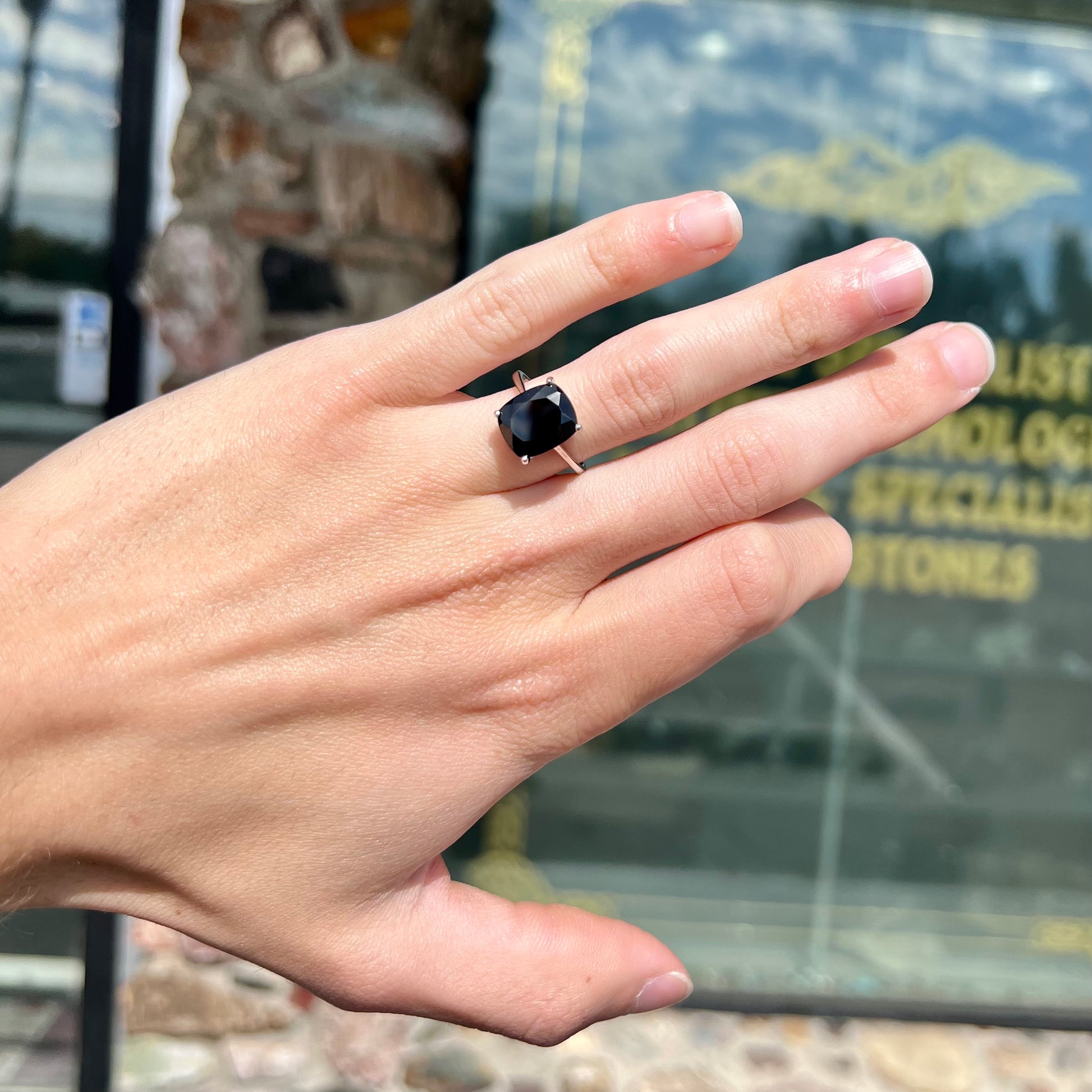 A cushion cut black spinel prong set in a sterling silver solitaire ring.