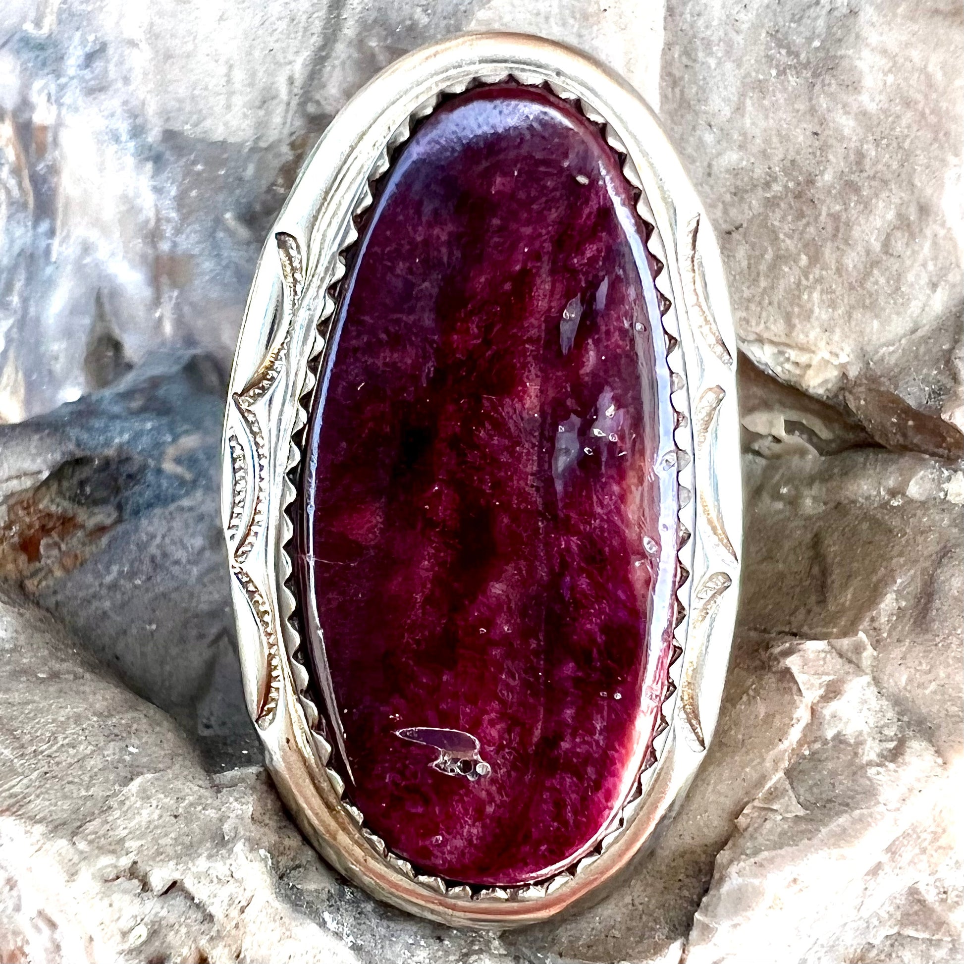 A sterling silver Navajo style ring set with a purple spiny oyster shell.