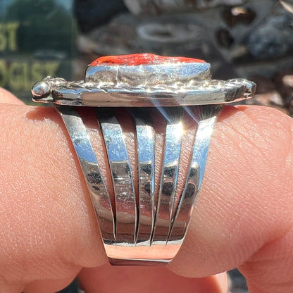 A sterling silver ring set with a polished red coral branch handmade by Navajo artist, Delbert Chatter.