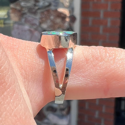 A split shank white gold boulder opal solitaire ring.  The stone has a natural hematite seam that runs through it.