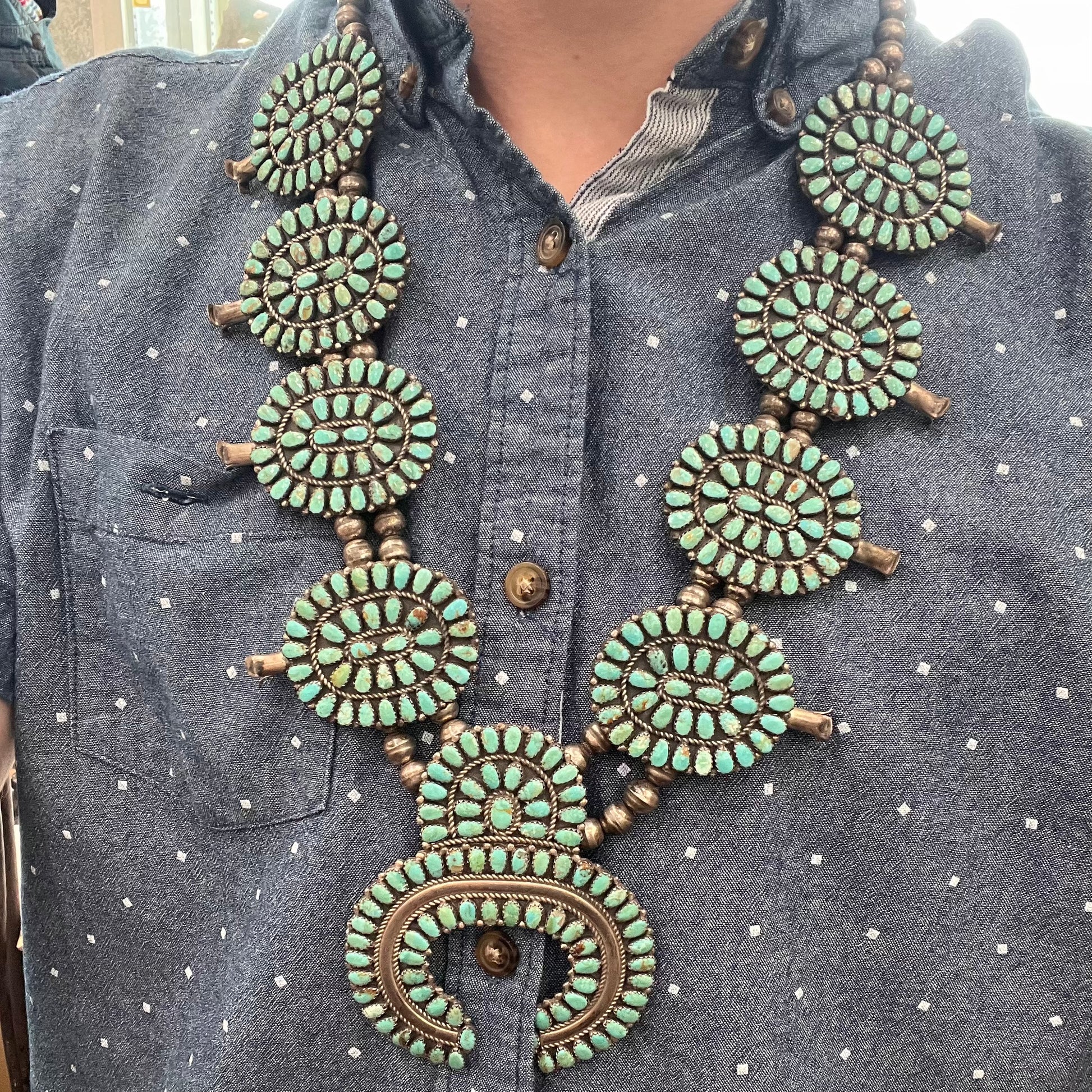 A Native American silver squash blossom turquoise petit point set with turquoise by Larry Moses Begay.