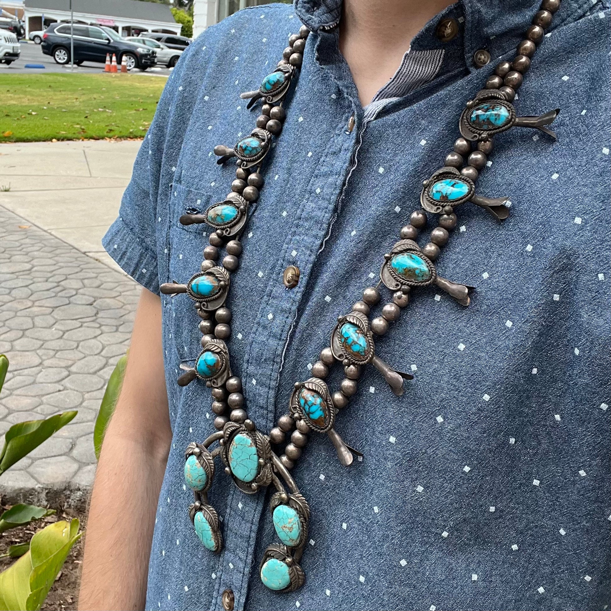 A silver Navajo men's squash blossom necklace set with Fox turquoise and Sonora turquoise.