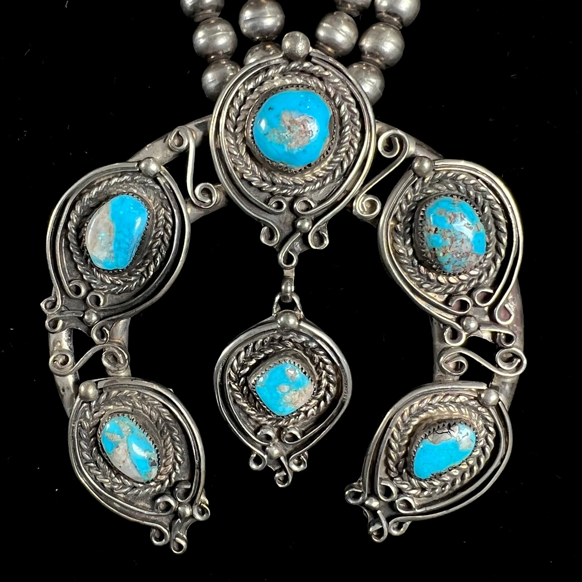 A men's Navajo silver squash blossom necklace set with Kingman turquoise stones.