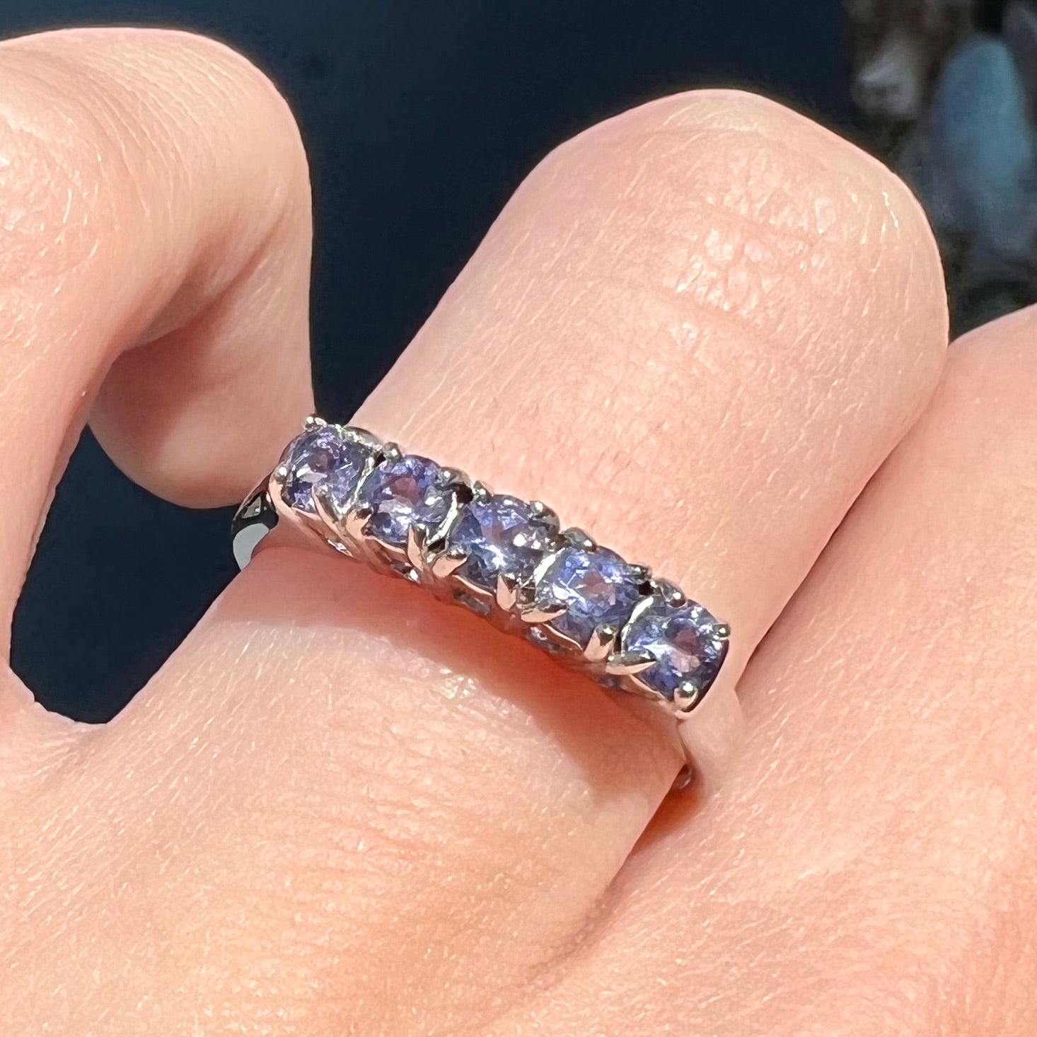 A sterling silver stackable ring set with five Standard Round Brilliant Cut tanzanite stones.