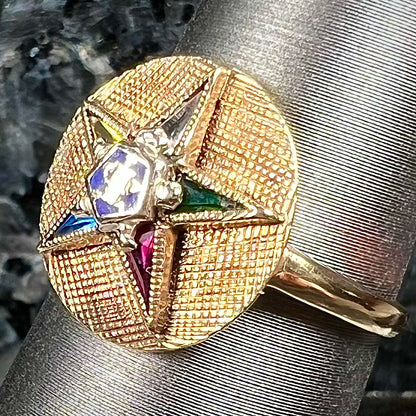 A gold ring set with multicolored synthetic sapphires forming a star with a blue enameled center, symbolizing the Order of the Eastern Star.