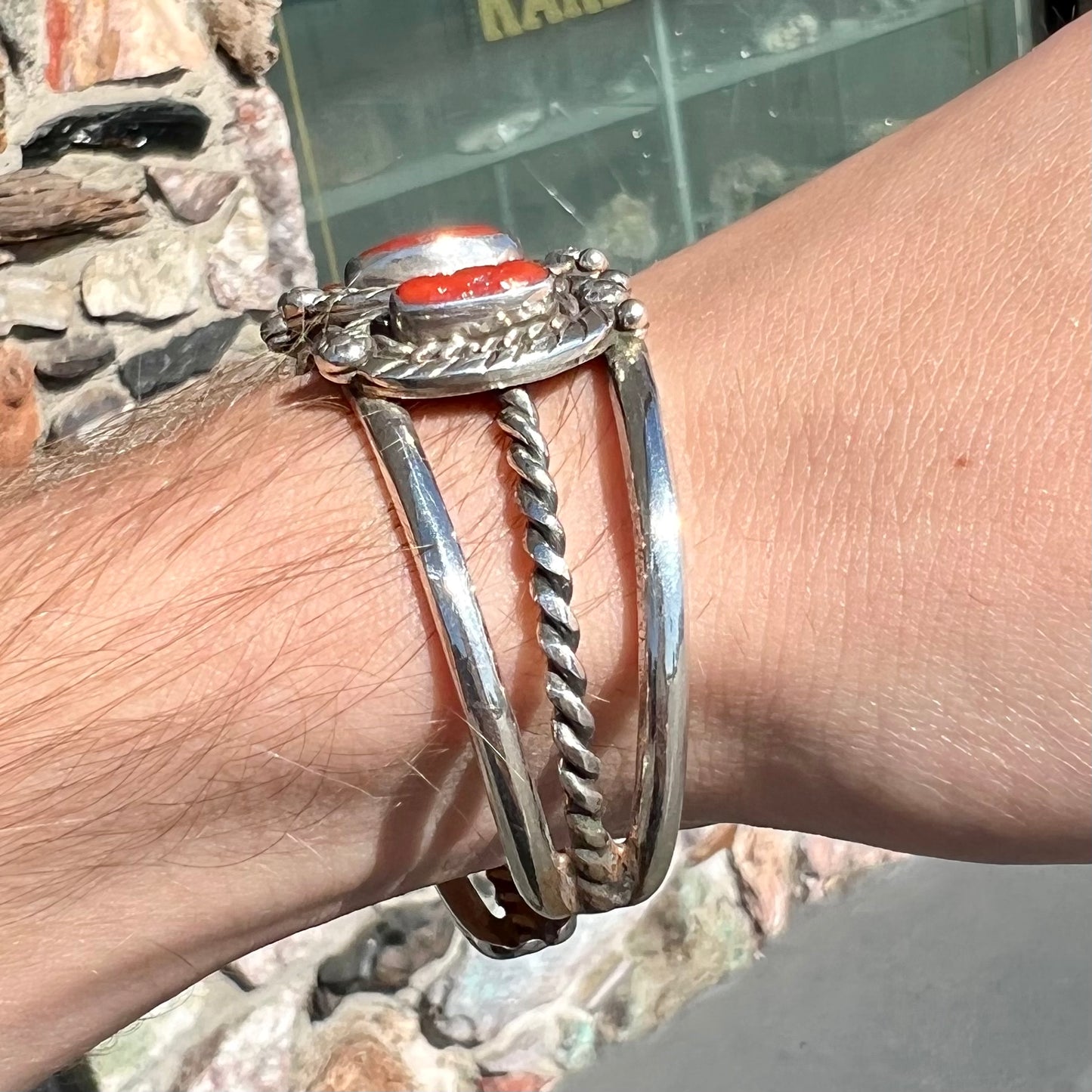 A sterling silver cuff bracelet set with polished coral branches handmade by Navajo artist, Delbert Chatter.