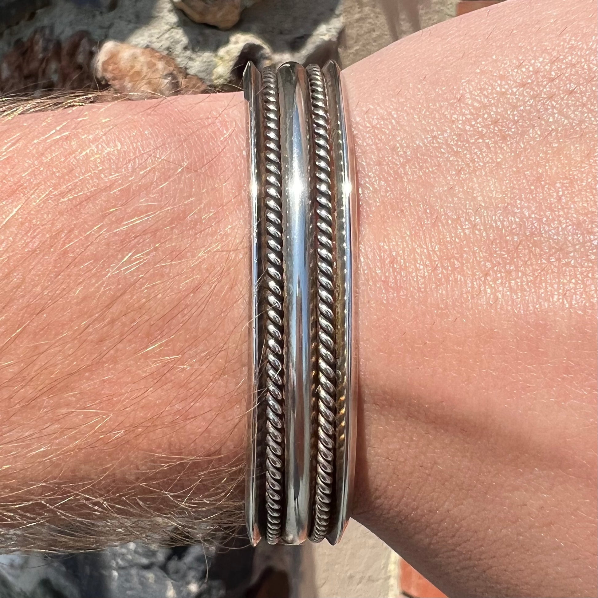 A handmade sterling silver cuff bracelet.  The bracelet is made with a rope wire.