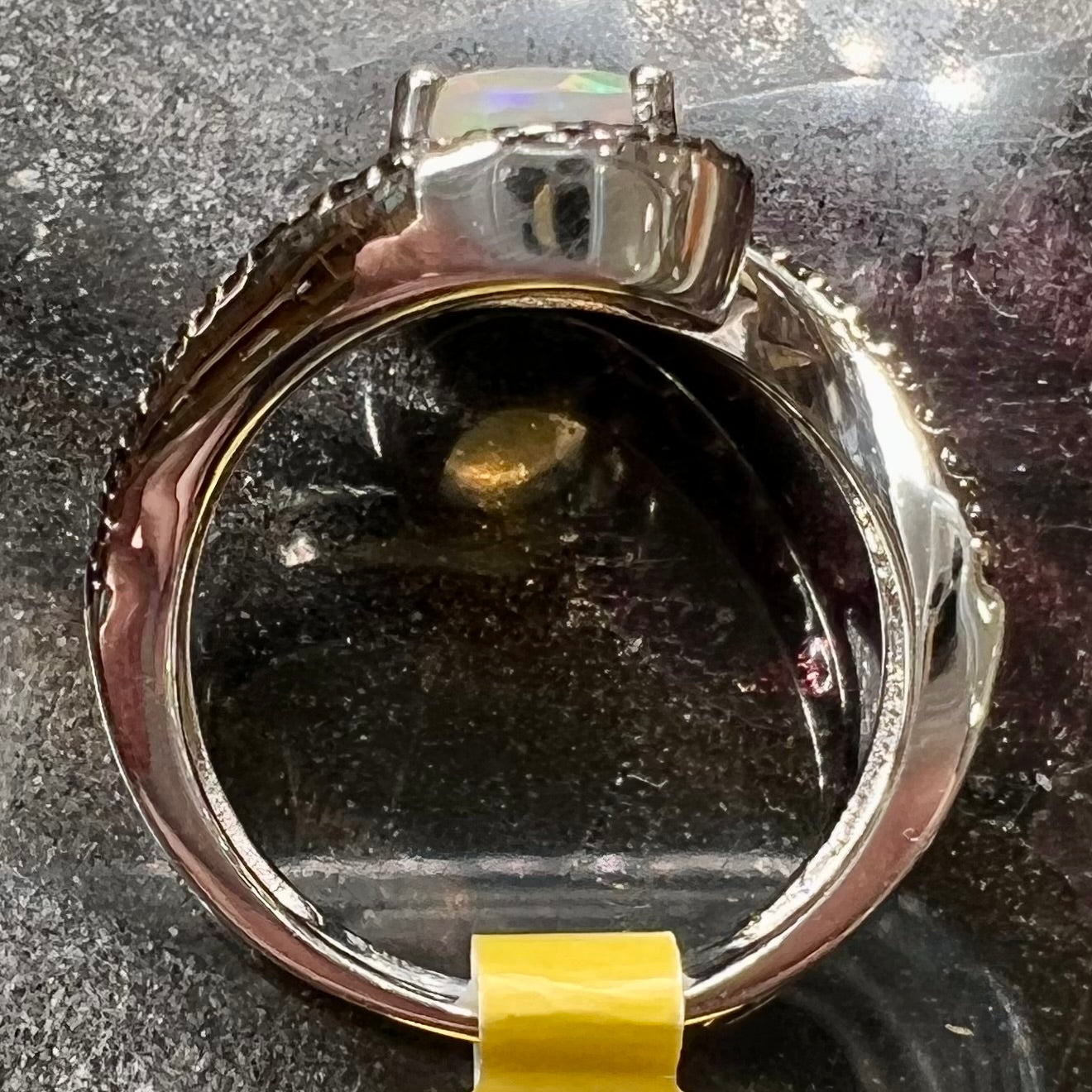 A sterling silver ring set with round black spinel stones and an oval cut, faceted Ethiopian opal.
