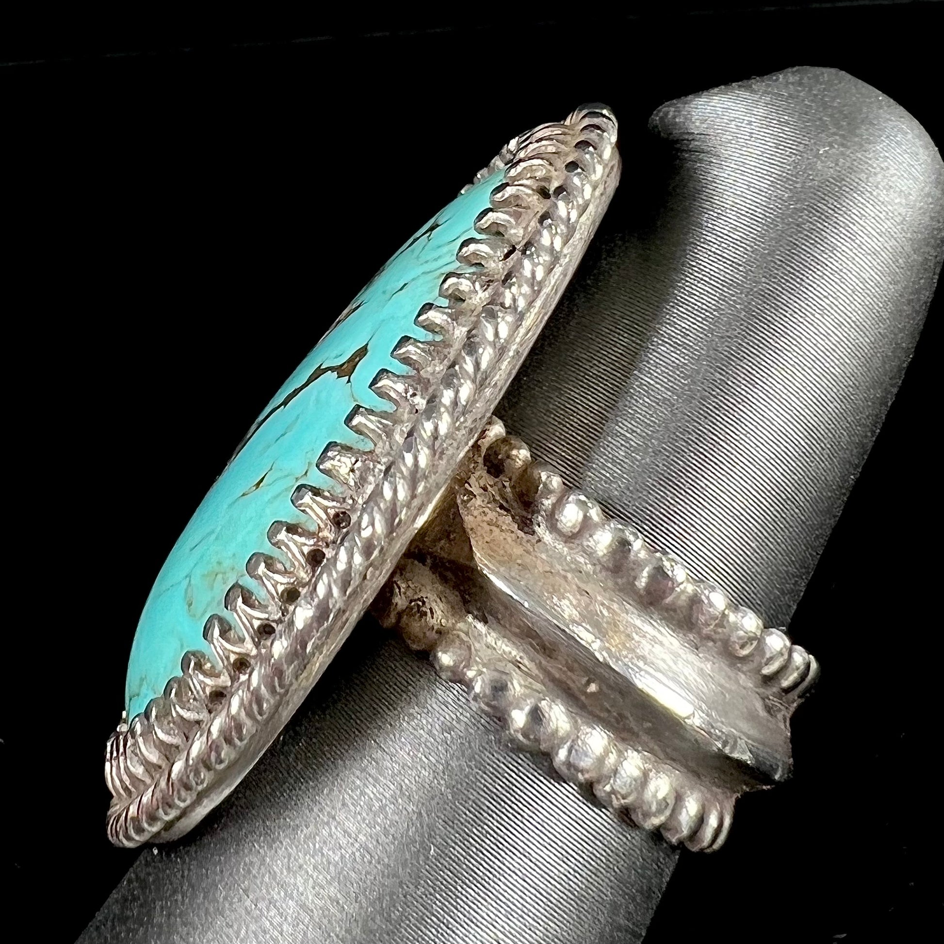 A sterling silver rope design ring set with a turquoise stone from Pilot Mountain Mine, Nevada.