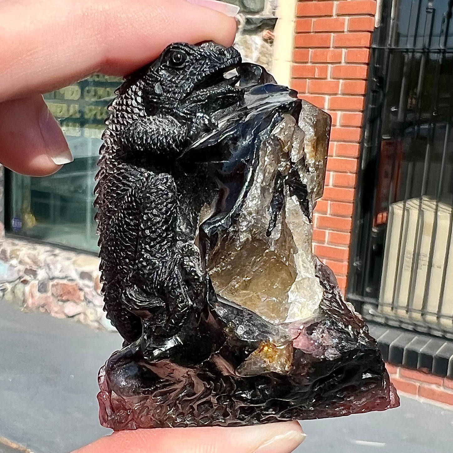 A stone lizard carved by artist, Ronald Stevens, from a liddicoatite tourmaline crystal.