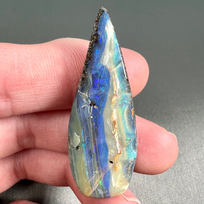 A loose, pear shaped boulder opal stone from Queensland, Australia.