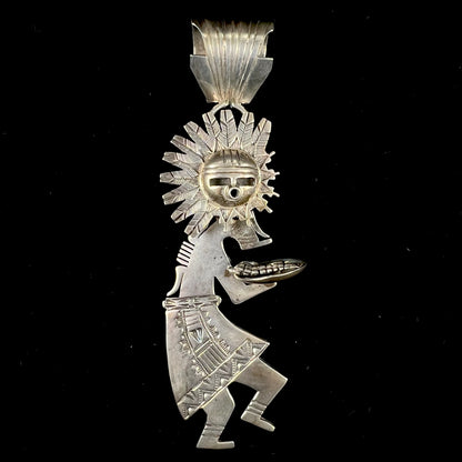 A "Navajo Sunface" kachina doll pendant made from sterling silver by artist Bennie Ration.  The piece measures four and a half inches long.