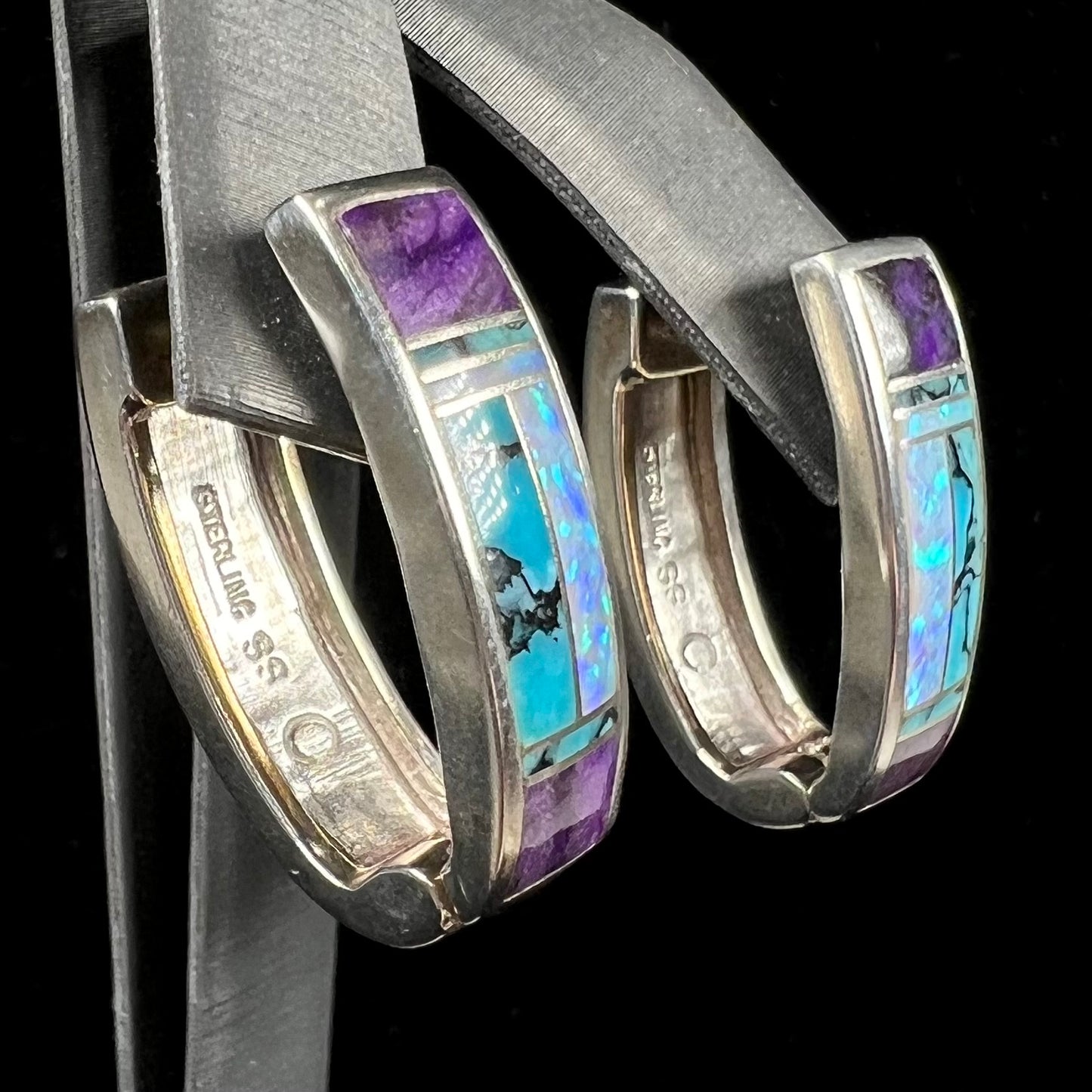 A pair sterling silver inlay earrings set with turquoise, sugilite, and lab created opal stones.