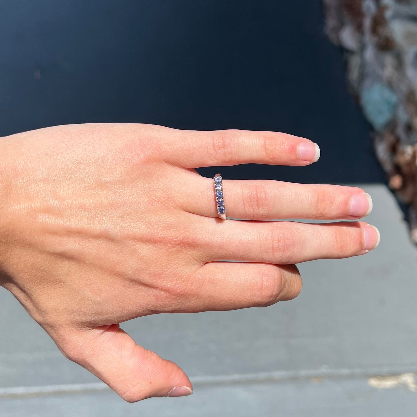 A sterling silver stackable ring set with five Standard Round Brilliant Cut tanzanite stones.