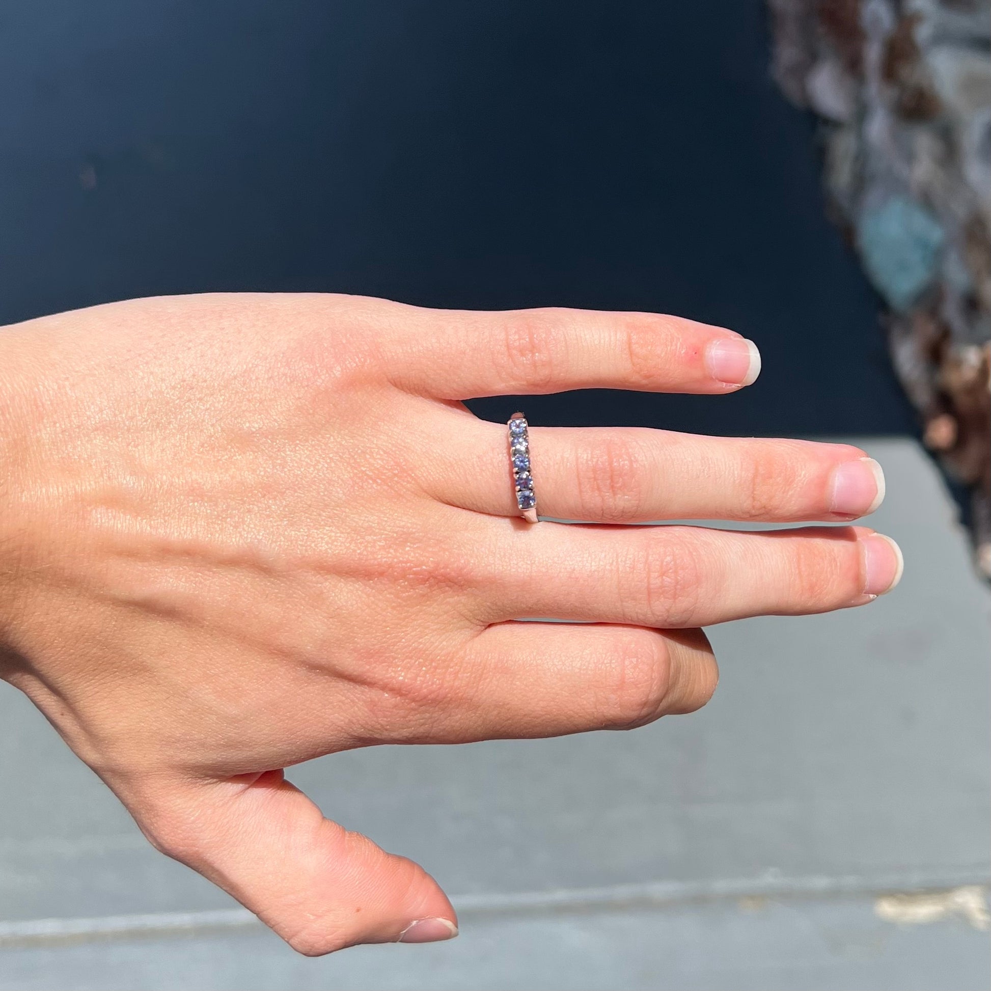 A sterling silver stackable ring set with five Standard Round Brilliant Cut tanzanite stones.