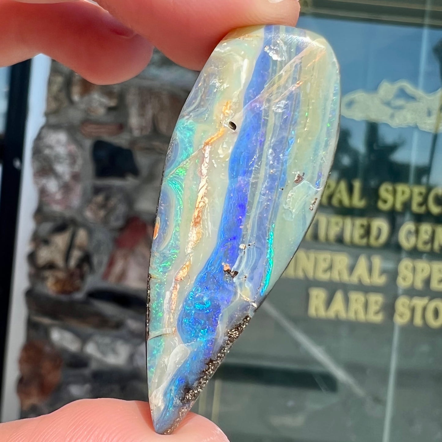 A loose, pear shaped boulder opal stone from Queensland, Australia.