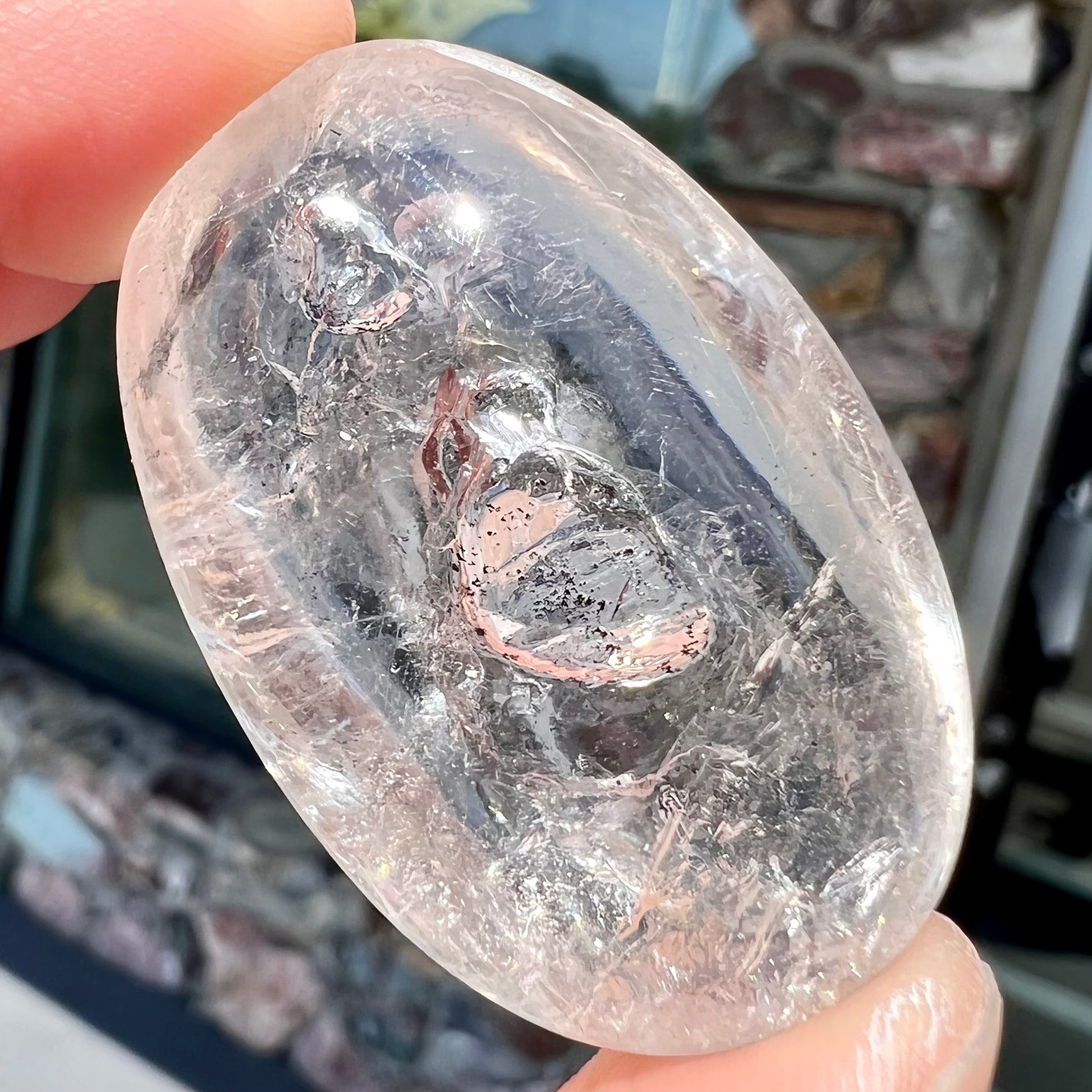 A polished clear enhydro quartz specimen that displays three phase inclusions.