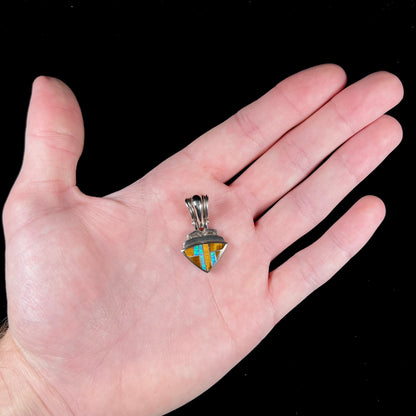 A Navajo-made pendant inlaid with tiger's eye and synthetic opal stones.