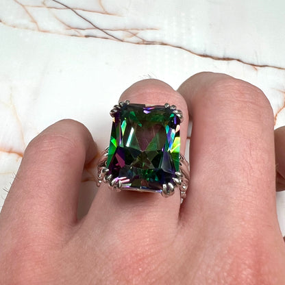 Emerald cut mystic topaz prong set in a decorative sterling silver ring.