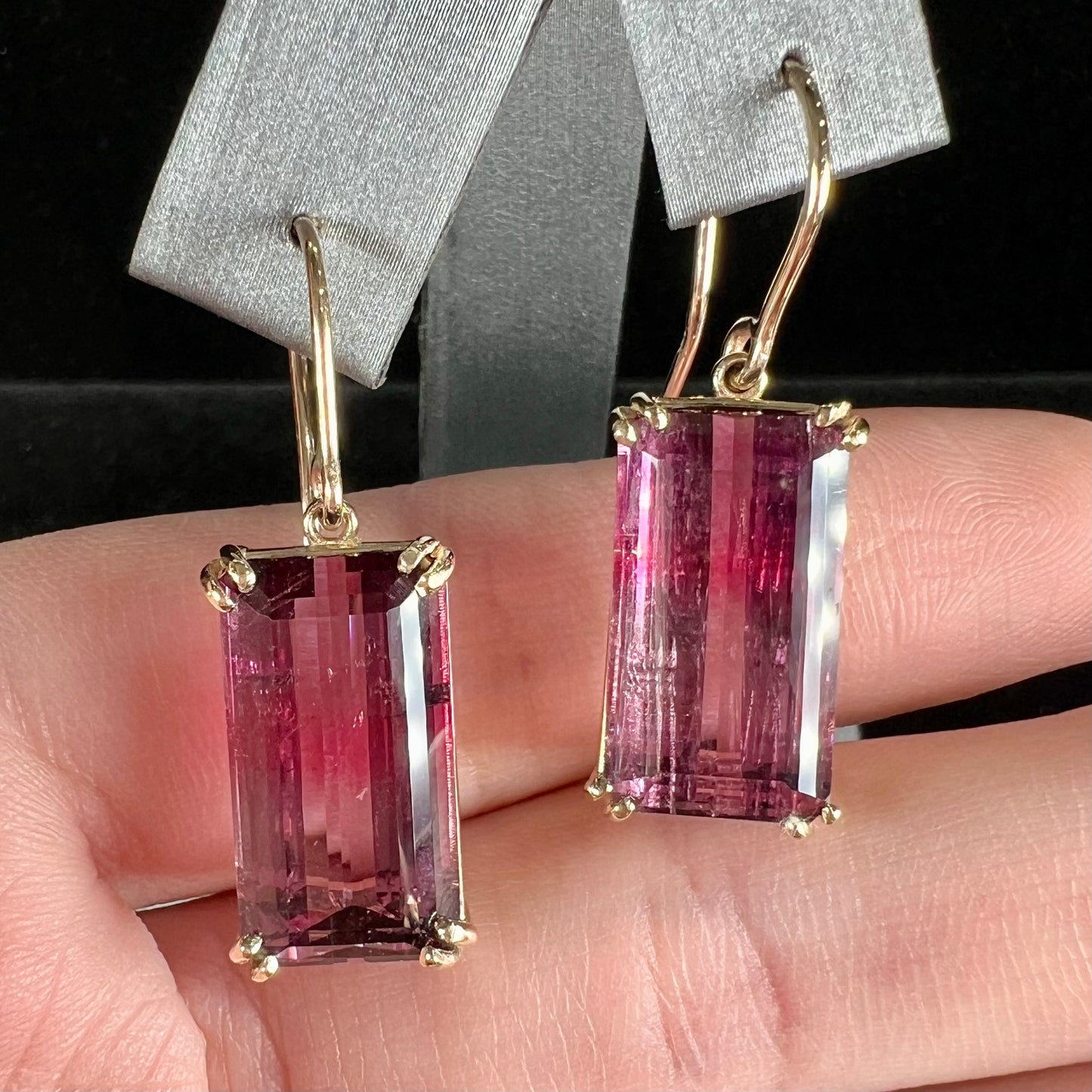 A pair of pink and magenta bicolor tourmaline dangle earrings handmade in 14kt yellow gold with basket settings and shepherd's hooks.