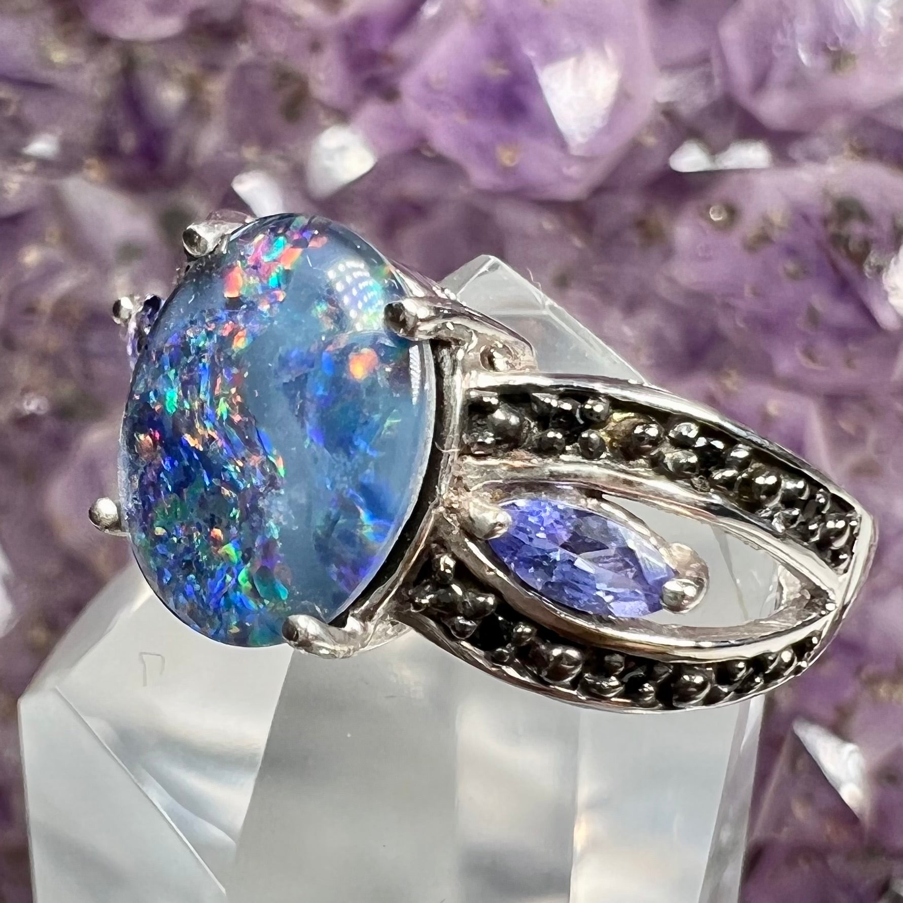 A sterling silver black opal triplet ring set with black spinel and marquise cut tanzanite accent stones.