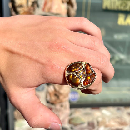 A yellow gold men's thug ring set with four fire agate stones resembling a spooky face.