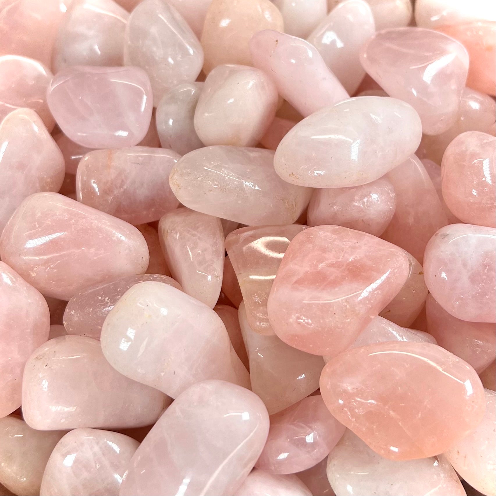 Pink, palm sized, tumble polished rose quartz stones.